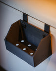 Tactic Engineering modular soap holder close up showing black SLS 3D printed container with drainage holes and bracket mounting clips for Hymer kitchen rail, empty view of the compact storage holder