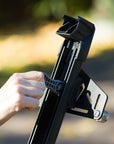 Person adjusting a black metal bracket to mount Snowboards and Skis on vehicles with magnets