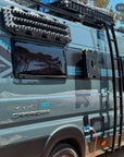 Fiat Ducato Carrera 184 campervan close up of rear side showing MaxTrax MK2 recovery boards and RotoPax containers mounted using Tactic Engineering magnetic quick release supports, rear ladder and roof rack with Carrera branding visible