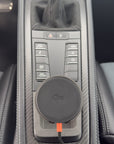 Tactic Engineering MagSafe Qi2 phone mount in the open centre console tray of a Porsche 981 Boxster Cayman with carbon fiber trim, no drilling