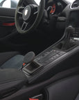 Tactic Engineering magnetic MagSafe phone mount installed in the open centre console tray of a Porsche 911 (991) interior with Alcantara trim, no drilling, no adhesive
