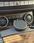 Close-up of the Tactic sintered-nylon MagSafe mount and McDodo Qi2 charger seated in the Mercedes CLS W218 / E-Class W212 center console cupholder.