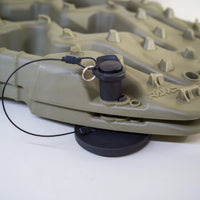 Close up of Tactic Engineering magnetic mount with stainless steel quick release pin and safety cable installed on olive green TRED GT recovery board, SLS 3D printed nylon mount on rubber coated neodymium magnet base visible underneath the board