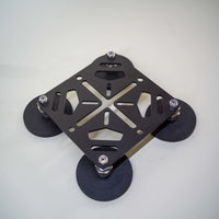 Tactic Engineering magnetic RotoPax mounting plate with four rubber coated neodymium magnets at corners, black powder coated steel X frame design with bolt mounting points for fuel water and gear containers, product photo on light gray background