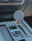 MagSafe-compatible Qi2 wireless charging puck on Cupra Formentor console phone mount, push-fit install beside the gear selector