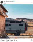 Customer photo from @big.adventure.van in Spain showing a Hymer campervan in desert landscape with MaxTrax recovery boards mounted on roof using Tactic Engineering magnetic quick release supports, mountains in background