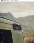 Customer photo from @thegreenoverlander showing MaxTrax recovery boards mounted on campervan roof rack using Tactic Engineering magnetic quick release supports, scenic mountain landscape in background
