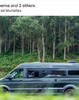 Dark overland van parked in lush green tropical forest with TRED recovery boards magnetically mounted on rear using Tactic Engineering magnetic supports, adventure van setup in Playa de Munielles by @iranberna showing off road expedition vehicle