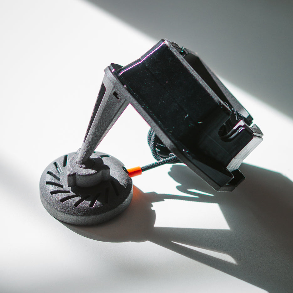 Side profile of the 2024+ Toyota Land Cruiser 250 MagSafe phone mount by Tactic Engineering, revealing the SLS 3D-printed nylon support arm structure and the reverse of the Qi2 magnetic charging puck — Swiss-engineered for off-road use