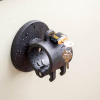 Tactic Engineering circular magnetic mount in black SLS 3D printed nylon with ABUS marine grade lock and key, water resistant design shown with rain droplets on surface