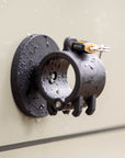 Side view of Tactic Engineering circular magnetic mount showing clamp mechanism for securing shovels, axes and tools, with ABUS lock and neodymium magnet base covered in water droplets
