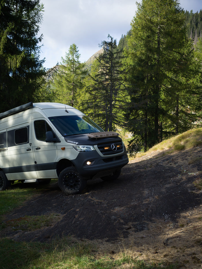 Mercedes Sprinter 4x4 campervan on an alpine forest trail in the Swiss mountains