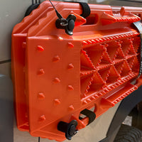 Orange Sumex recovery boards mounted on a white van side panel with a Tactic Engineering magnetic quick-release pin and safety cable