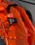 Close-up of a Tactic Engineering quick-release pin and rubber-coated neodymium magnet holding a Sumex recovery board against a white van body