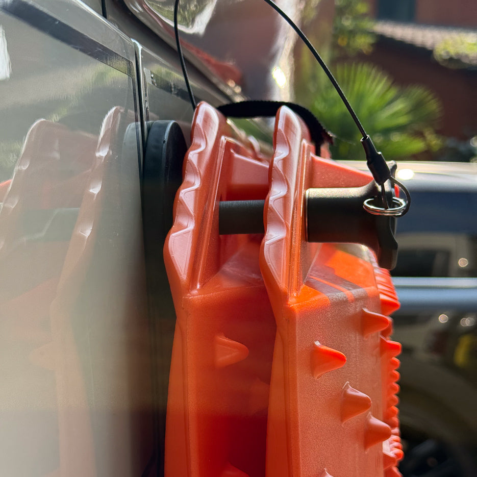 Quick-release pin with stainless ring and safety cable securing a Sumex recovery board to a van panel