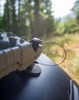 Tactic Engineering TRED magnetic mounts installed on curved vehicle body panel with anti theft cable, holding TRED recovery board securely with 55 kg pull force neodymium magnets in forest setting