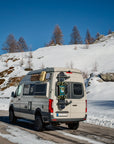 Tactic Engineering magnetic ski and snowboard carrier mounted on rear of camper van in the Swiss Alps, holding skis and snowboard without a roof rack