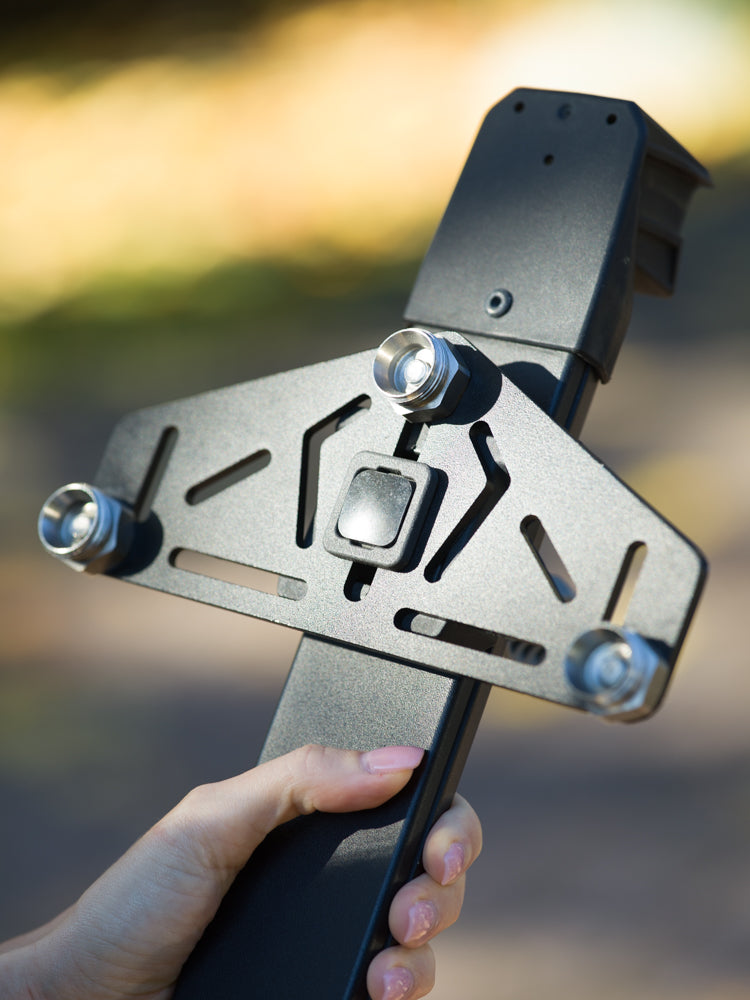 Person adjusting a black metal bracket to mount Snowboards and Skis on vehicles with magnets