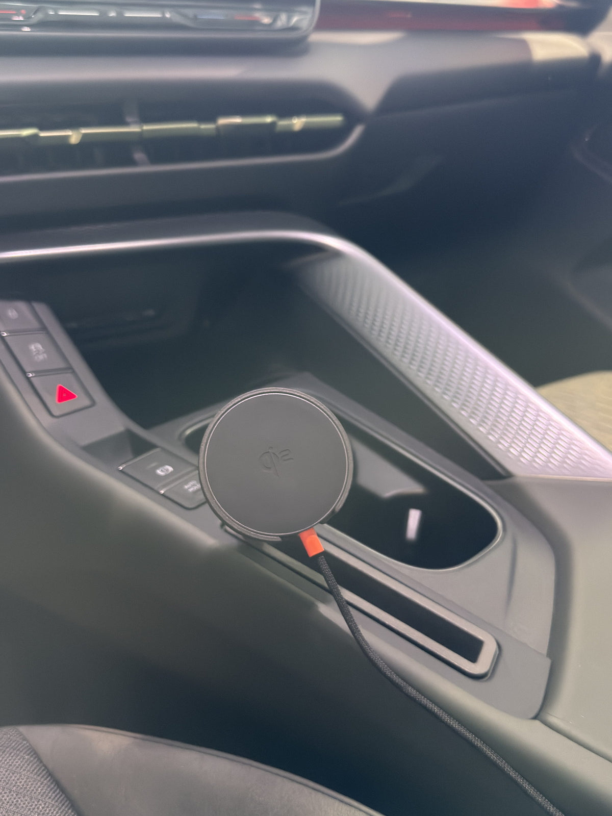 Magnetic Qi2 phone mount installed in the Cupra Terramar 2024 centre console. The charging head sits in the front cupholder beside the hazard and drive mode buttons. No drilling. No adhesive. Made in Switzerland.
