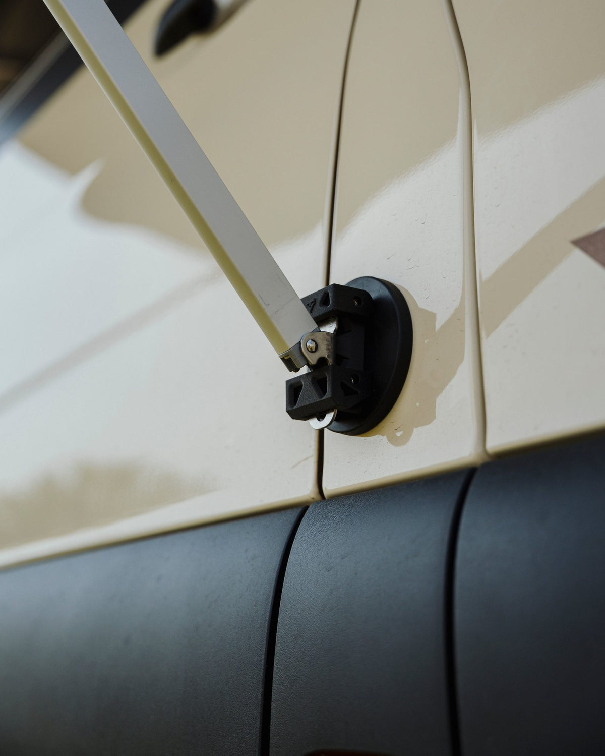 Close-up of Tactic Engineering magnetic Fiamma awning mount with quick-release pin holding the awning arm on the Weinsberg X-Pedition 4x4 Sprinter by Ferrigato Camper