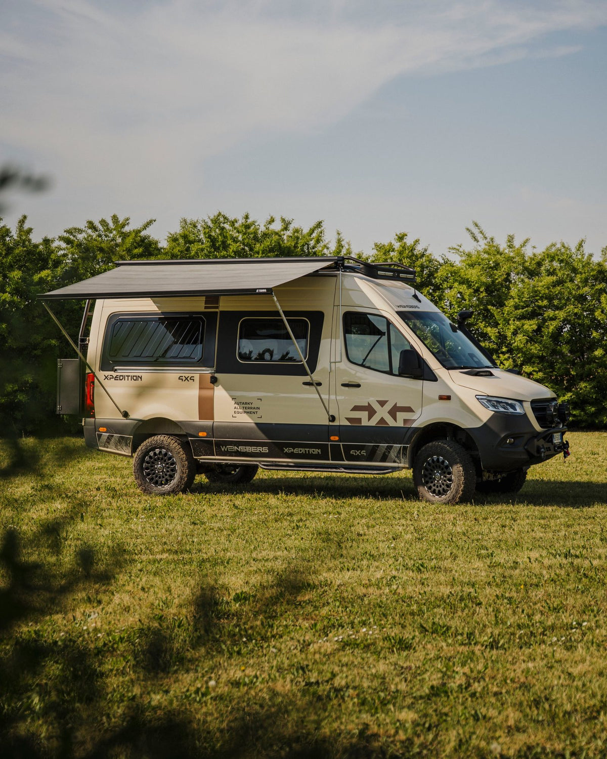 Weinsberg X-Pedition 4x4 Sprinter conversion by Ferrigato Camper with Thule Omnistor awning extended, mounted to the van side using Tactic Engineering magnetic awning supports — no drilling, no permanent fixings