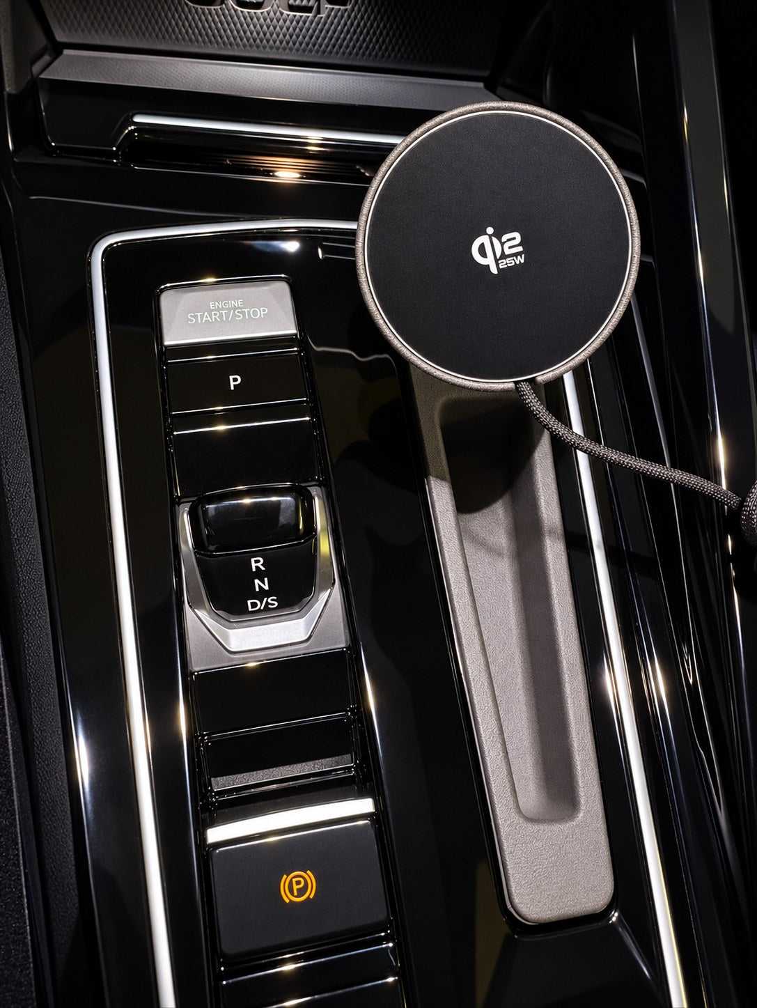 Uchwyt na telefon Tactic Engineering zamontowany w konsoli środkowej VW Golf 8 obok wybieraka biegów, z ładowarką bezprzewodową Qi2 MagSafe, wyprodukowany w Szwajcarii