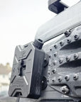 Close up of RotoPax petrol fuel container magnetically mounted on vehicle using Tactic Engineering magnetic plate, MaxTrax MK2 recovery boards visible alongside, detail shot showing secure magnetic attachment on wet vehicle exterior