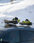 Close up of skis held on a Mercedes-Benz CLS roof by Tactic Engineering magnetic mounts with a Thule SnowPack carrier
