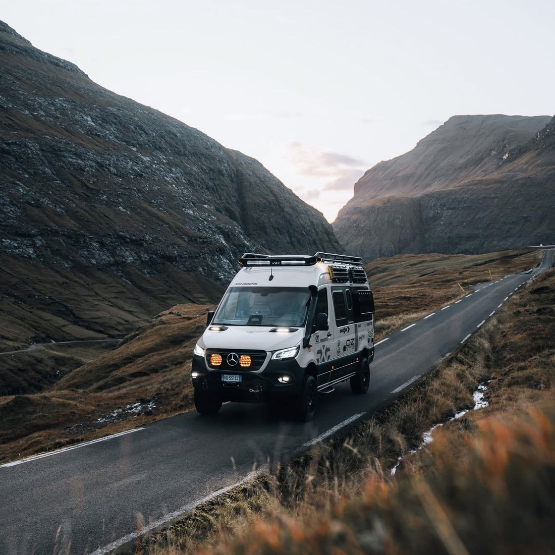 Mercedes Sprinter 4x4 with MaxTrax recovery boards on Tactic Engineering magnetic quick release mounts, mountain road in the Faroe Islands at dusk