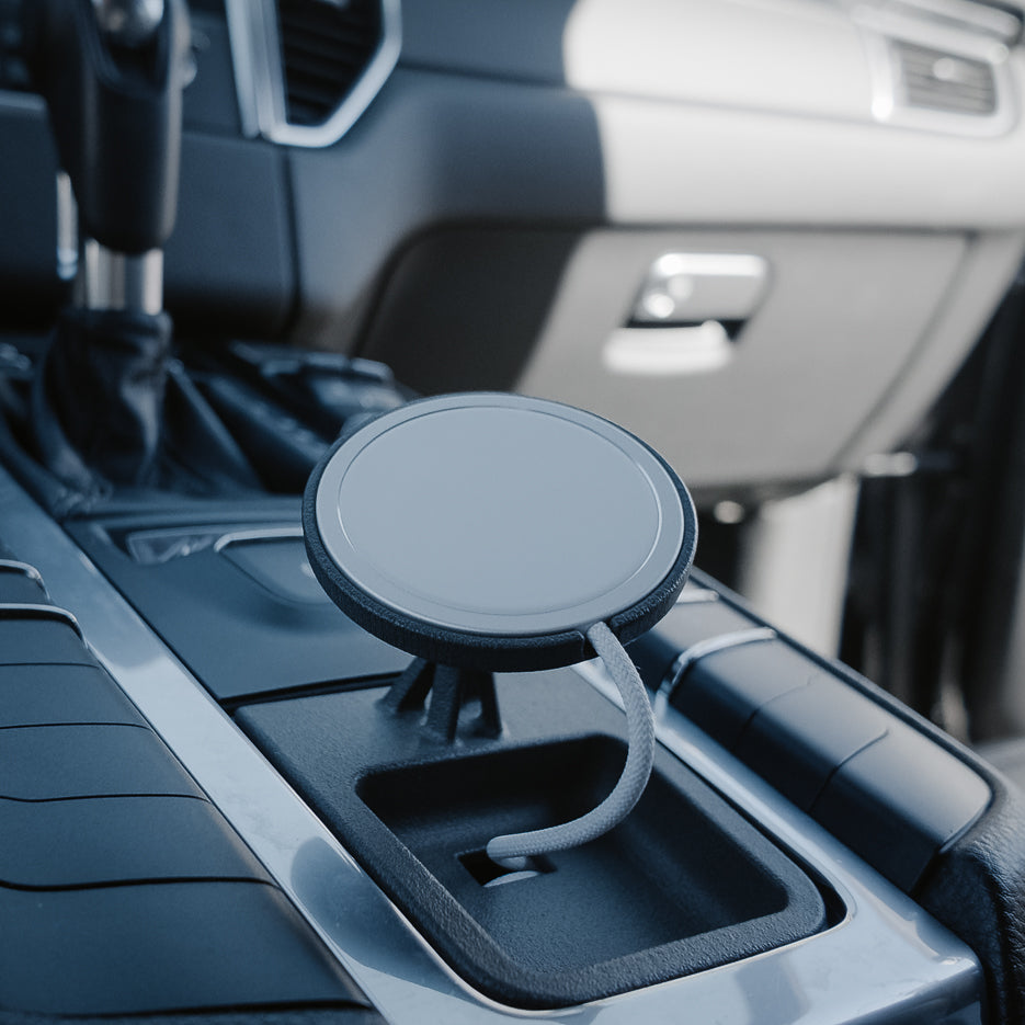 Tactic Engineering phone mount installed in the centre console of a Porsche Macan 95B (2014-2021) without ashtray. Vehicle-specific SLS nylon base, MagSafe-compatible Qi2 charger, braided cable. Made in Switzerland.