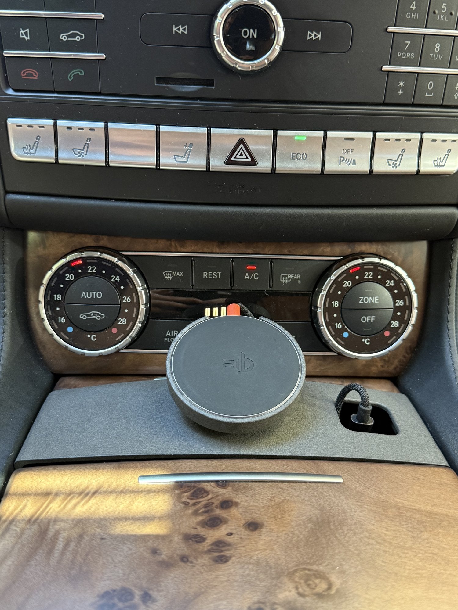 Tactic MagSafe phone holder installed in the center console cupholder of a Mercedes E-Class W212, with the McDodo Qi2 charger mounted below the climate controls.