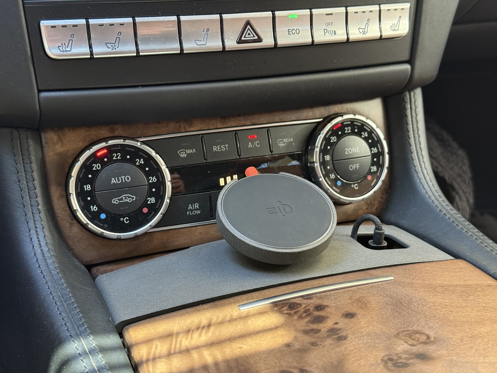 Close-up of the Tactic sintered-nylon MagSafe mount and McDodo Qi2 charger seated in the Mercedes CLS W218 / E-Class W212 center console cupholder.